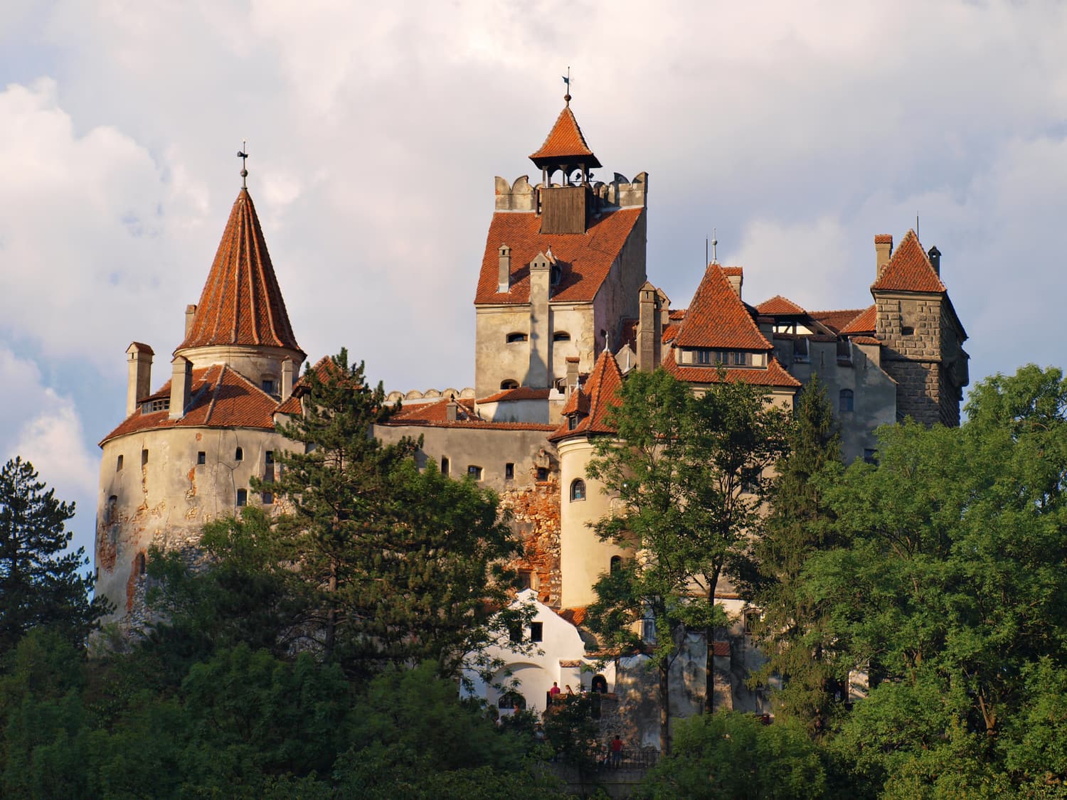 Bran Castle with its towers and red roofs rising above the trees