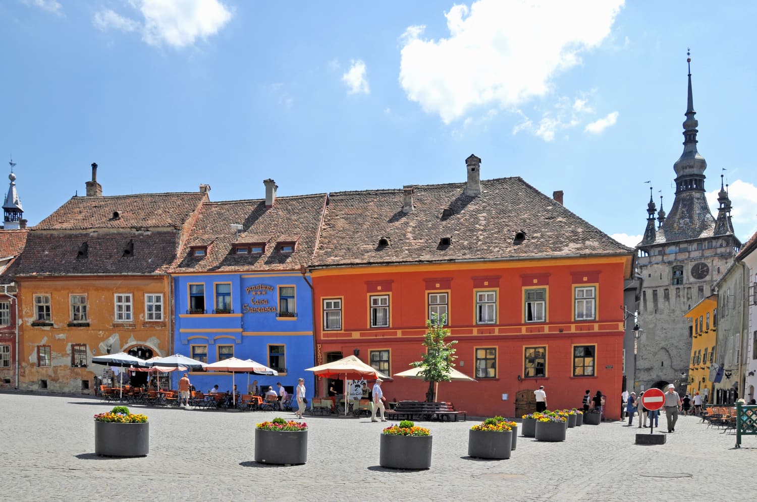 Colourful houses on the Citadel Square of Sighișoara with the Clock Tower behind