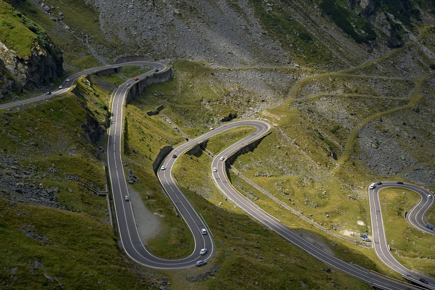 The Transfăgărășan road zigzagging up the green slopes of the Făgăraș Mountains